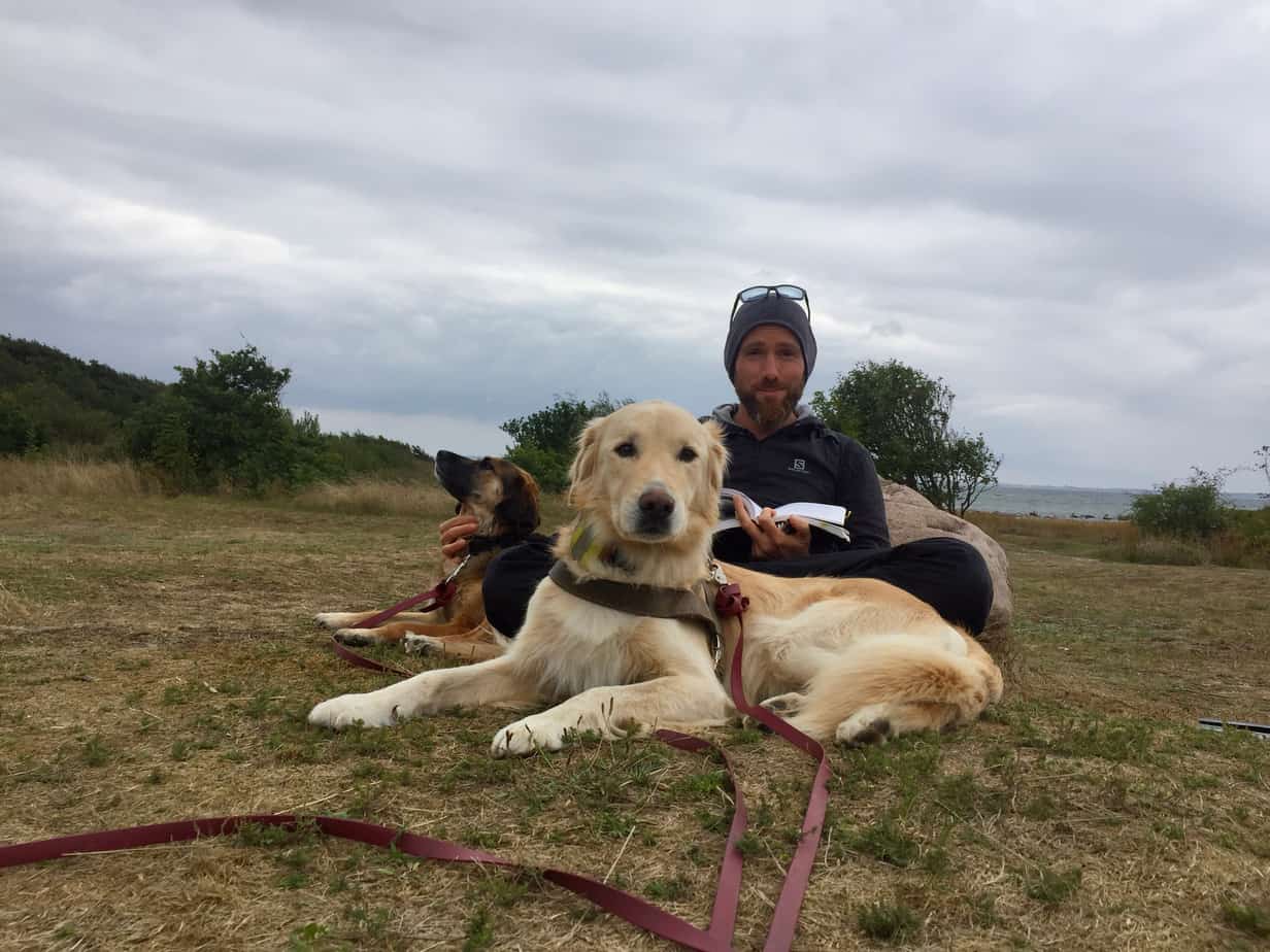 Carsten Christiani sitting with Nanuk and Leelou, reading a book